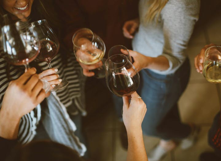 Bild på en grupp människor som skålar med vinglas.