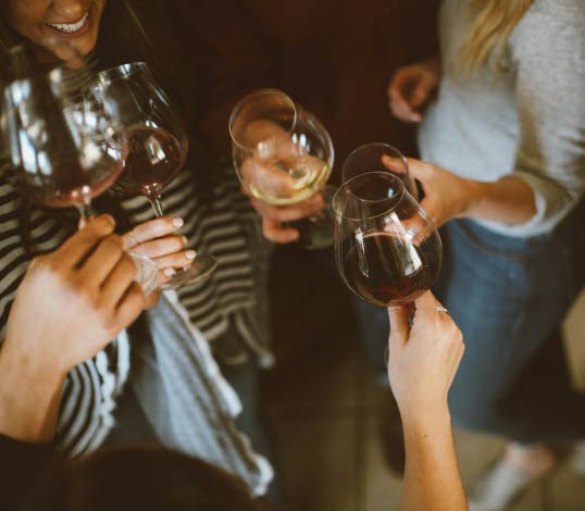 Bild på en grupp människor som skålar med vinglas.