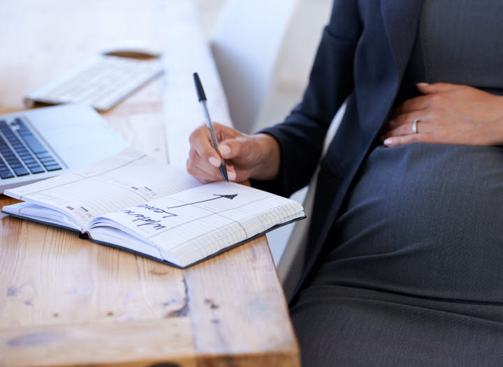 Gravid kvinna planerar för föräldraledighet. 